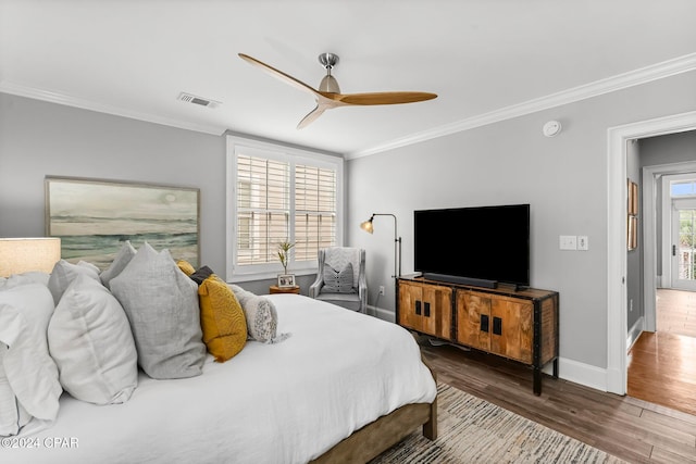 bedroom featuring a ceiling fan, wood finished floors, baseboards, ornamental molding, and visible vents
