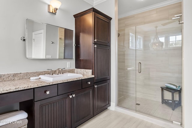 full bathroom featuring a shower stall, vanity, and ornamental molding