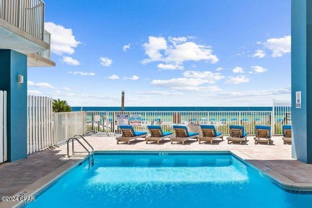 view of swimming pool featuring a water view