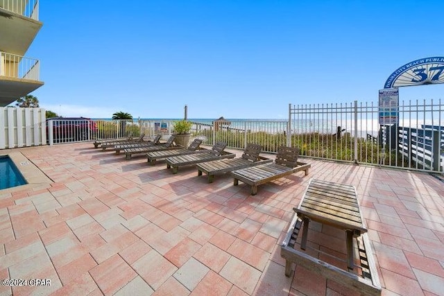 view of patio with a water view and a view of the beach