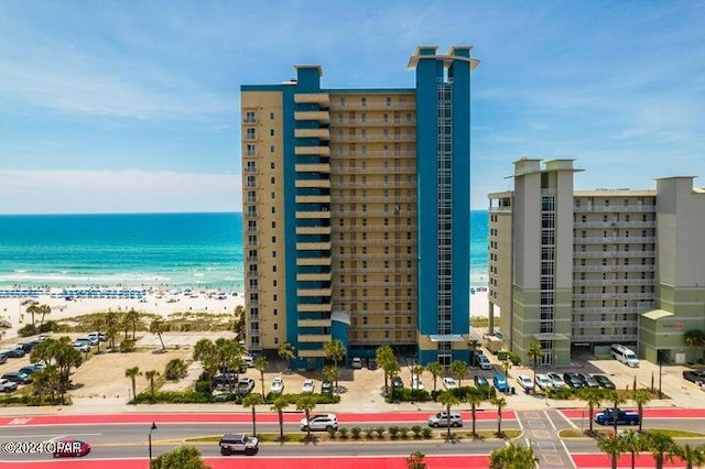 view of property with a water view and a beach view