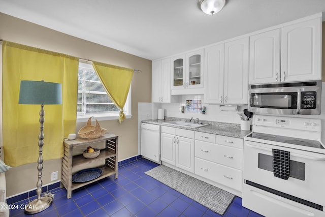 kitchen with white cabinetry, sink, white appliances, and light stone counters