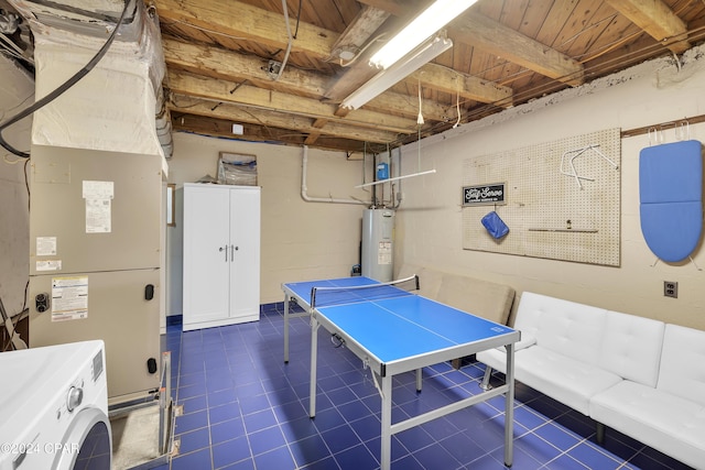 recreation room with heating unit, electric water heater, and washing machine and dryer