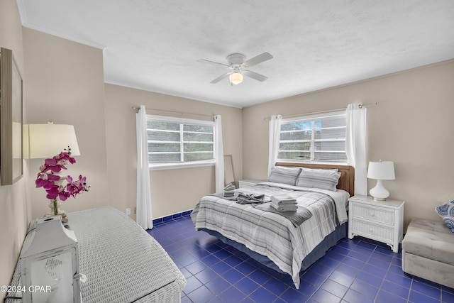 bedroom with ceiling fan, a textured ceiling, and dark tile patterned floors