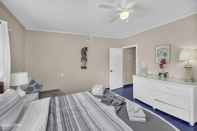 bedroom with ceiling fan, ornamental molding, and dark tile patterned floors