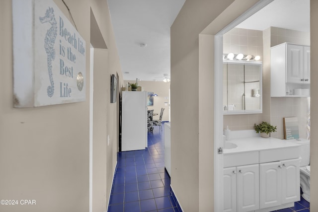 hallway with dark tile patterned flooring and sink