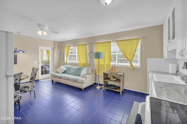 tiled living room featuring ceiling fan and sink