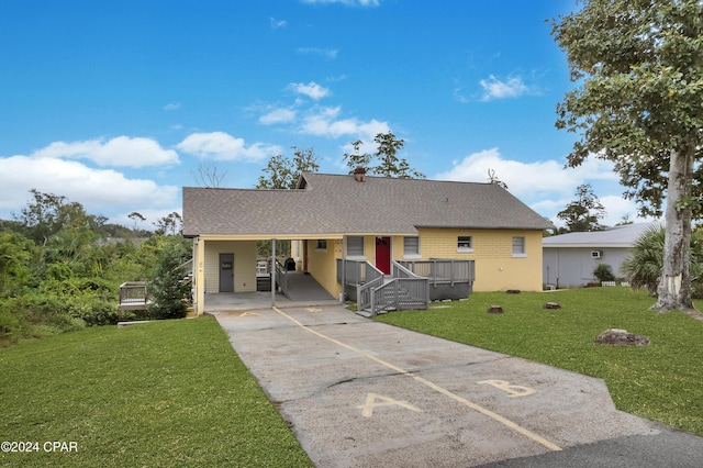 view of front of house with a carport and a front lawn