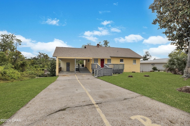 ranch-style house featuring a front lawn and a carport