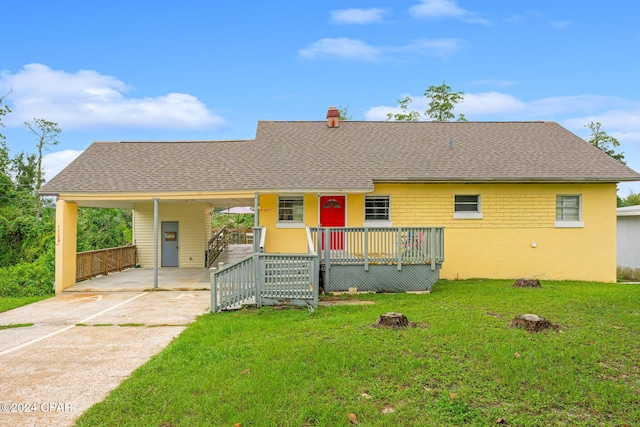 ranch-style home featuring a carport and a front lawn