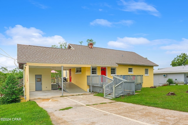 view of front of property with a front yard and a carport