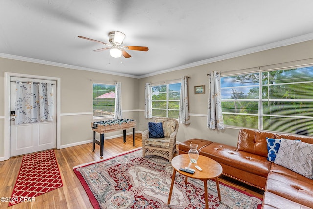 living room with crown molding, light hardwood / wood-style flooring, and ceiling fan