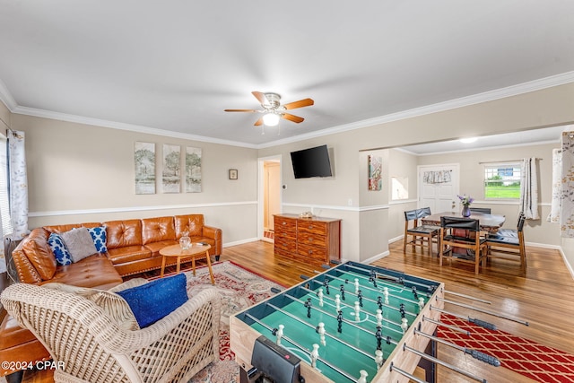 living room with wood-type flooring, ornamental molding, and ceiling fan