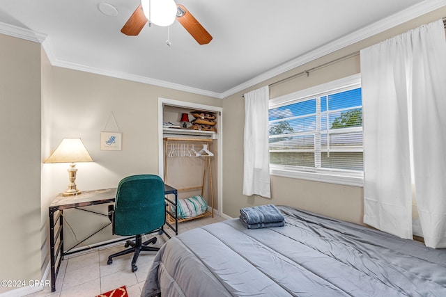 tiled bedroom with ceiling fan, ornamental molding, and a closet