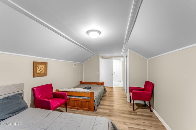 bedroom featuring vaulted ceiling and light wood-type flooring