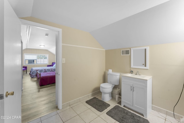 bathroom featuring vaulted ceiling, vanity, tile patterned floors, and toilet