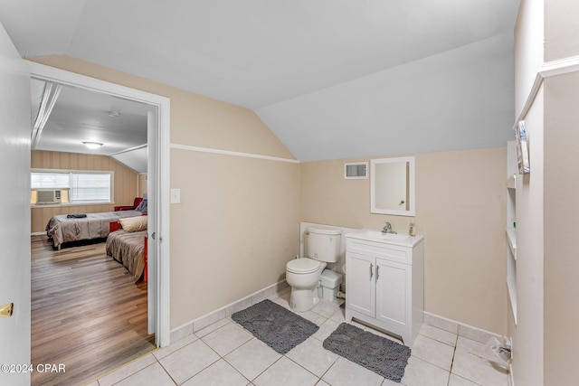 bathroom featuring lofted ceiling, toilet, tile patterned flooring, and vanity