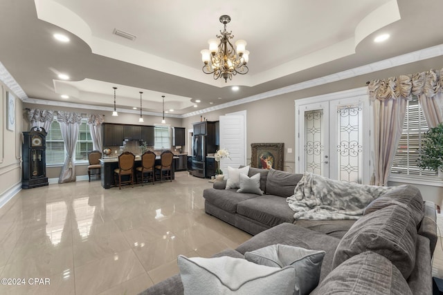 living room with a tray ceiling and an inviting chandelier