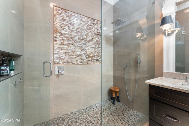 bathroom featuring vanity, a shower with shower door, and ornamental molding