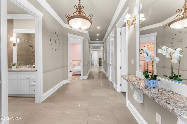 corridor featuring crown molding, sink, and light tile patterned flooring