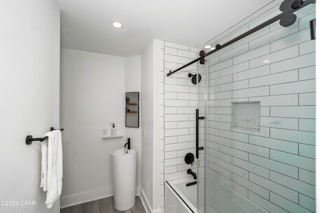 bathroom featuring tiled shower / bath and wood-type flooring