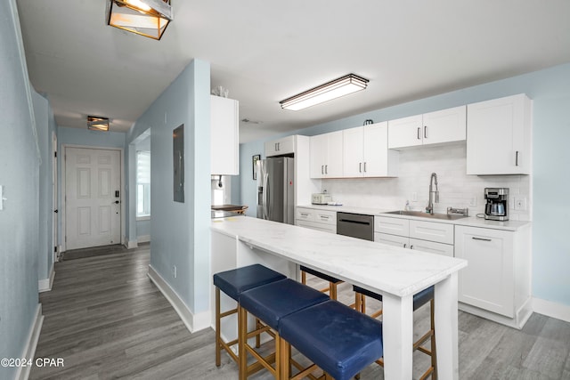 kitchen featuring stainless steel appliances, white cabinets, sink, and light hardwood / wood-style flooring