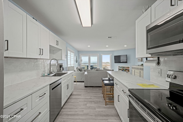 kitchen featuring white cabinets, sink, and appliances with stainless steel finishes