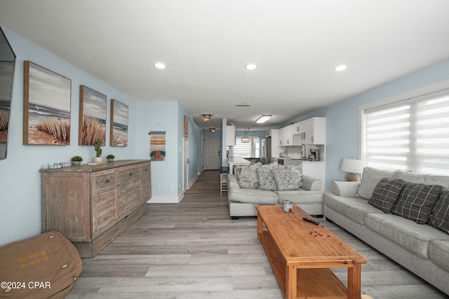 living room with sink and light hardwood / wood-style flooring