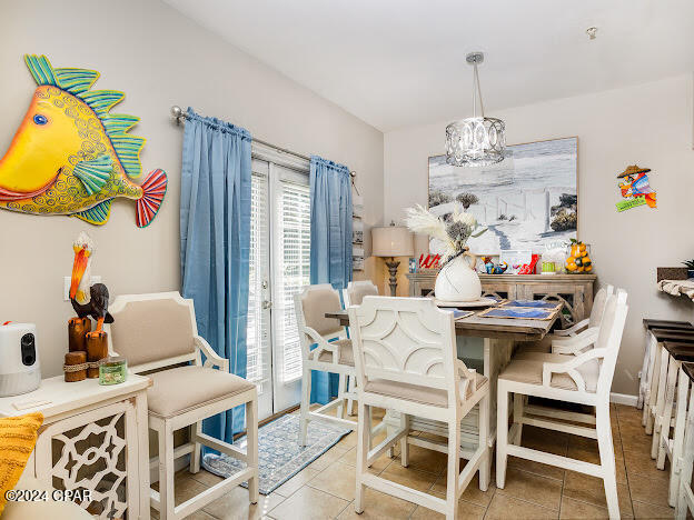 tiled dining room with an inviting chandelier