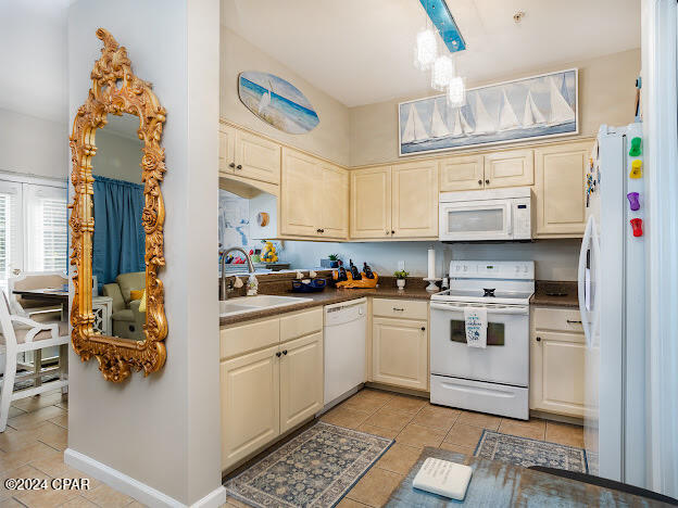 kitchen featuring light tile patterned floors, white appliances, and sink