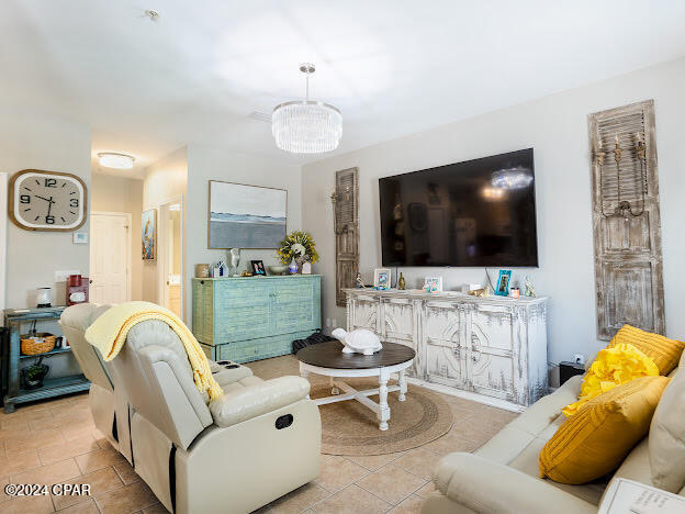 living room featuring light tile patterned floors and a notable chandelier