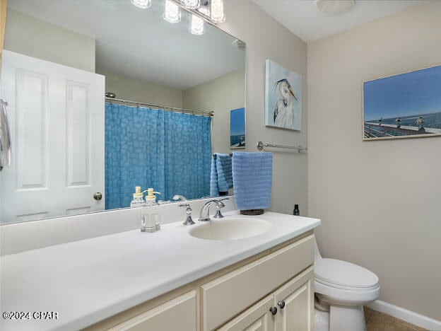 bathroom featuring tile patterned flooring, vanity, and toilet