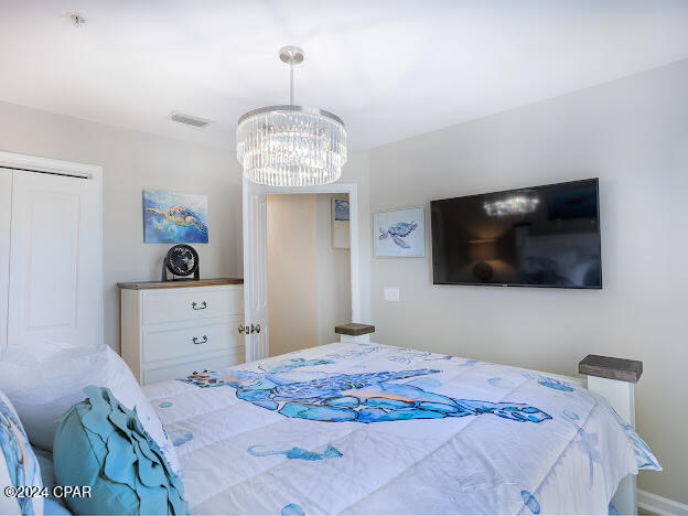 bedroom featuring a chandelier and a closet