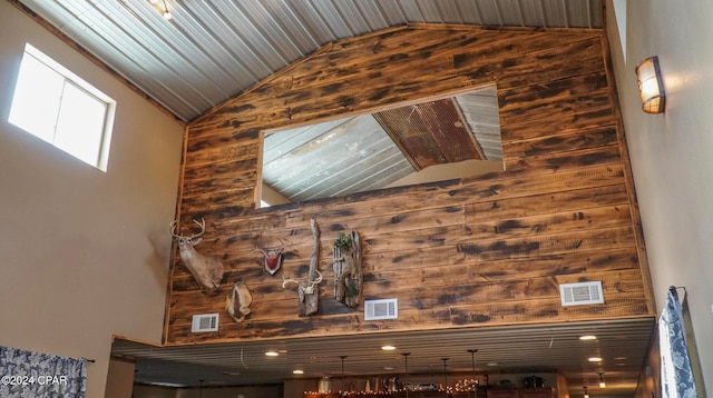 interior space with high vaulted ceiling and wooden walls