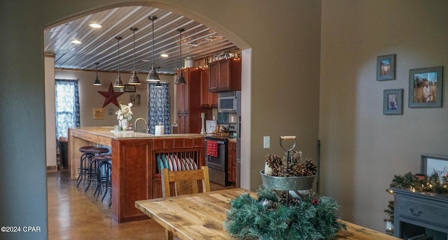 kitchen with appliances with stainless steel finishes, decorative light fixtures, and wood ceiling