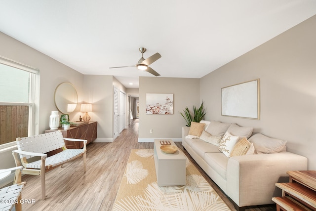 living room with light hardwood / wood-style flooring and ceiling fan