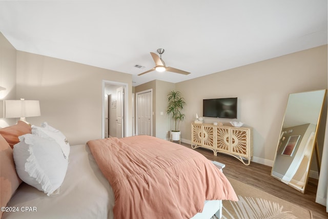 bedroom featuring baseboards, visible vents, ceiling fan, wood finished floors, and a closet