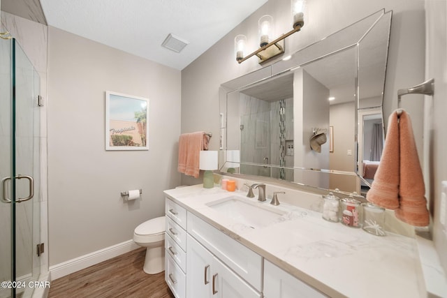 bathroom with visible vents, a stall shower, vanity, wood finished floors, and baseboards