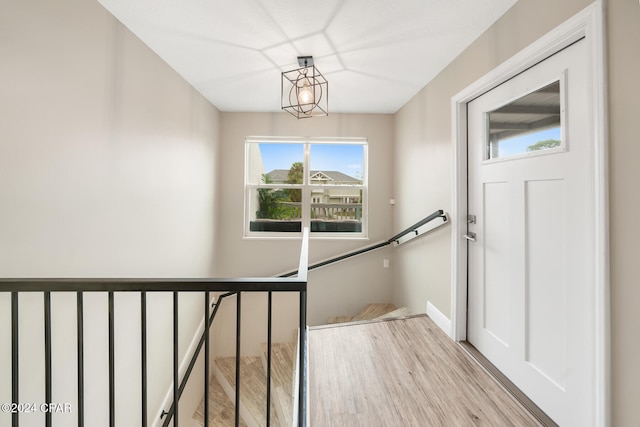 staircase featuring an inviting chandelier and hardwood / wood-style flooring