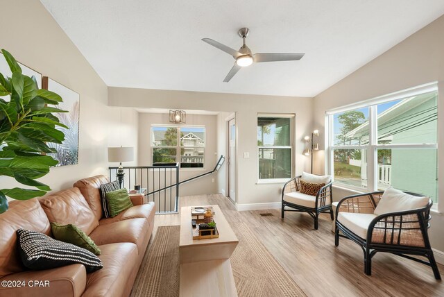 living room featuring a wealth of natural light, light hardwood / wood-style flooring, ceiling fan, and vaulted ceiling