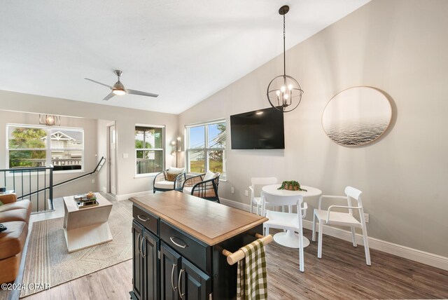 living room with ceiling fan with notable chandelier, light wood-type flooring, and vaulted ceiling