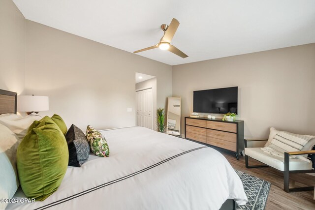 bedroom with ceiling fan, wood-type flooring, and a closet