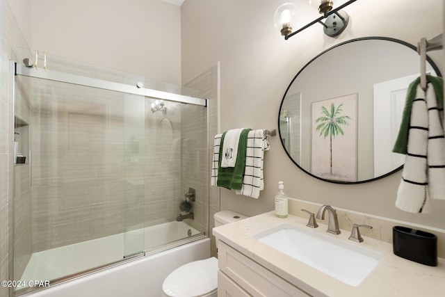 bathroom with combined bath / shower with glass door, vanity, and toilet