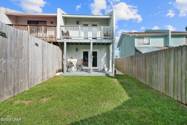 back of property with a yard, french doors, and a patio