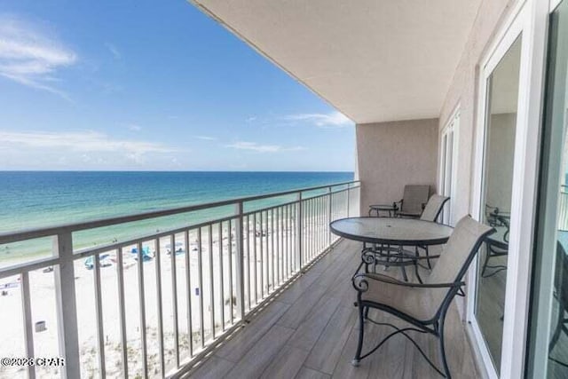 balcony featuring a water view and a view of the beach