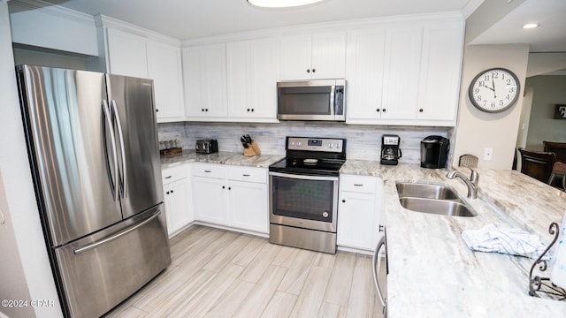 kitchen featuring light stone countertops, white cabinetry, appliances with stainless steel finishes, and sink