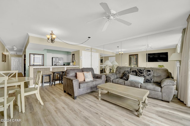 living room featuring ceiling fan with notable chandelier, light wood-type flooring, and ornamental molding