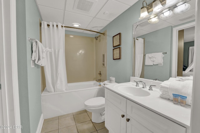 full bathroom with a drop ceiling, shower / tub combo, vanity, tile patterned floors, and toilet