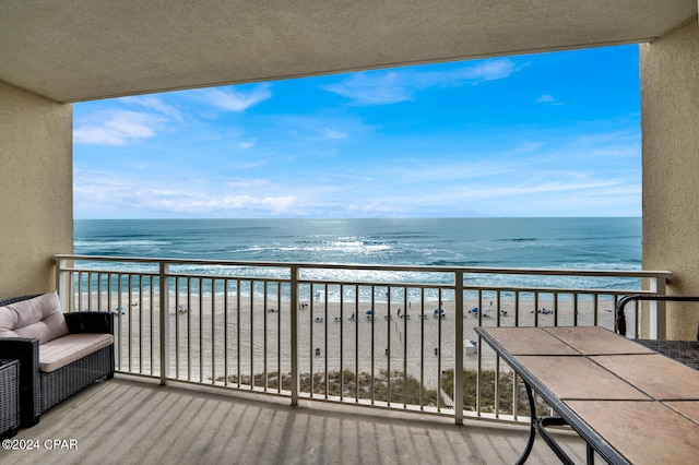 balcony featuring a water view and a view of the beach