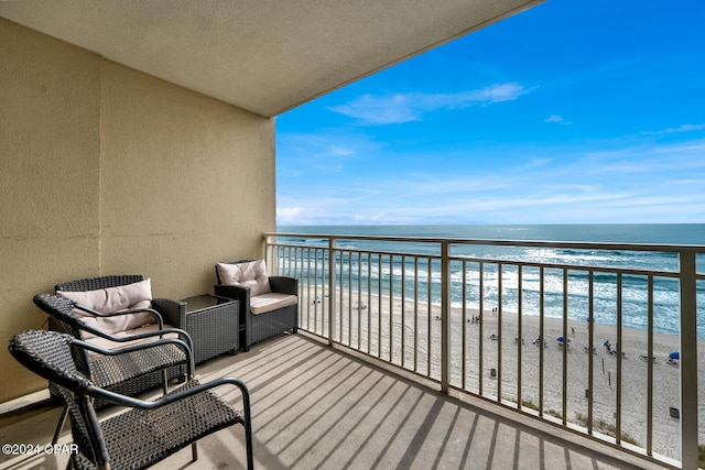 balcony featuring a view of the beach and a water view